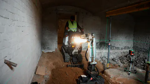 Minibagger im Gewölbekeller beim Bodenaushub in Potsdam-Krampnitz