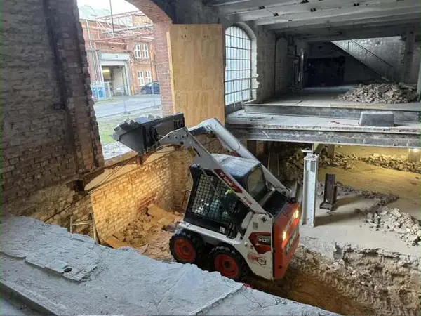 Kompaktlader räumt Bauschutt bei der Entkernung einer Halle