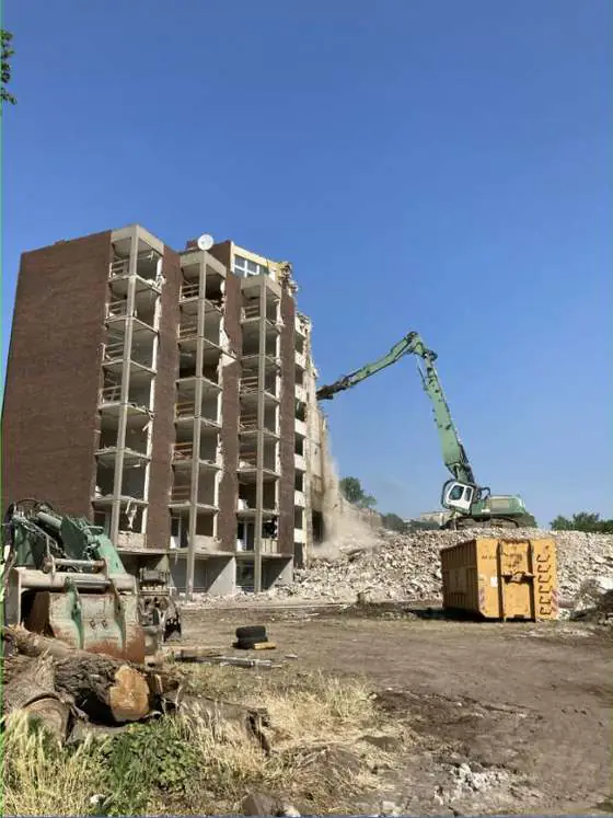 Abriss eines mehrgeschossigen Gebäudes mit Longfront-Bagger